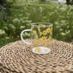 استکان دسته‌دار با طرح گل بابونه زرد و دسته شیری - نمای کامل